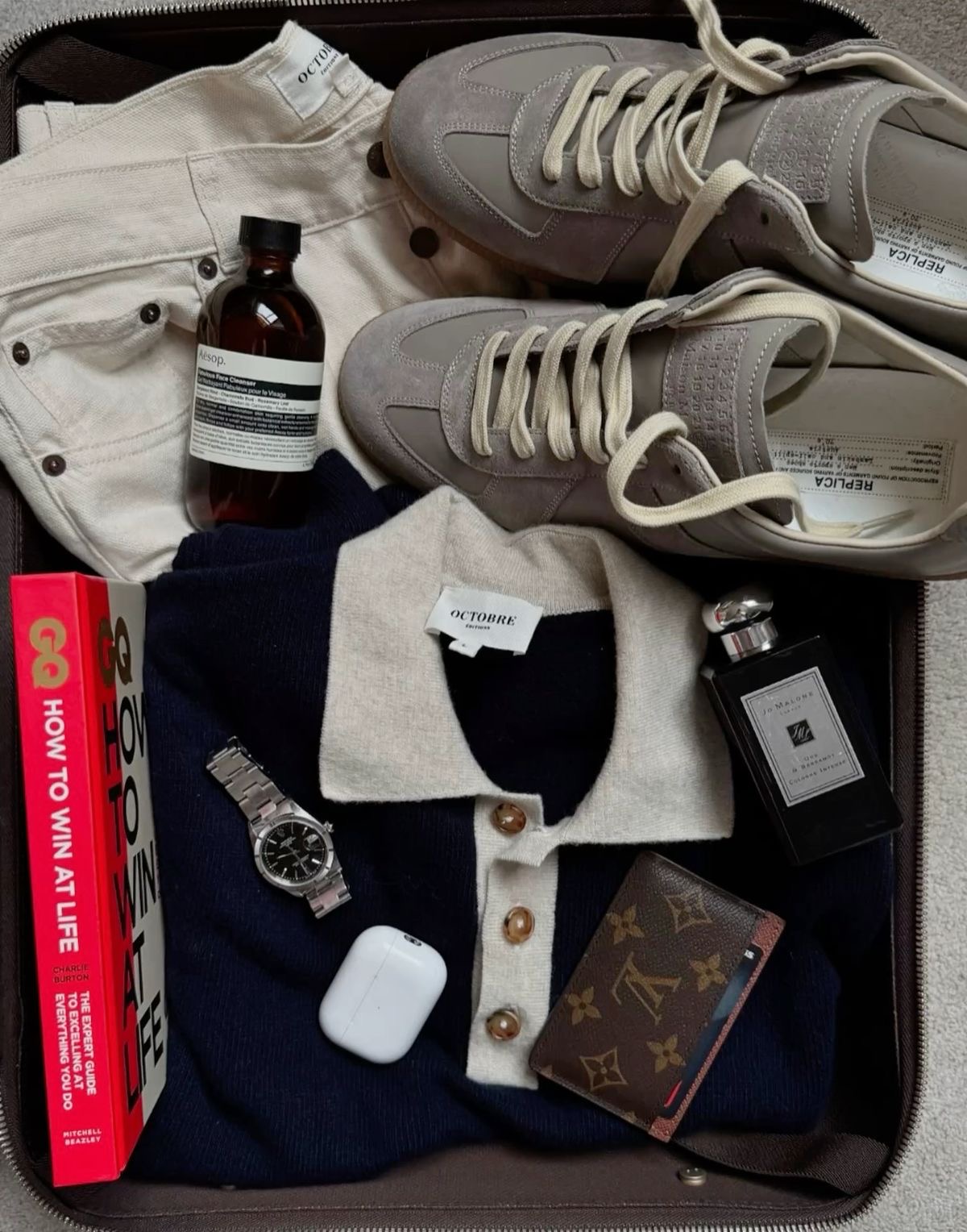 Men's flatlay — suede sneakers, navy knit polo, cream denim
