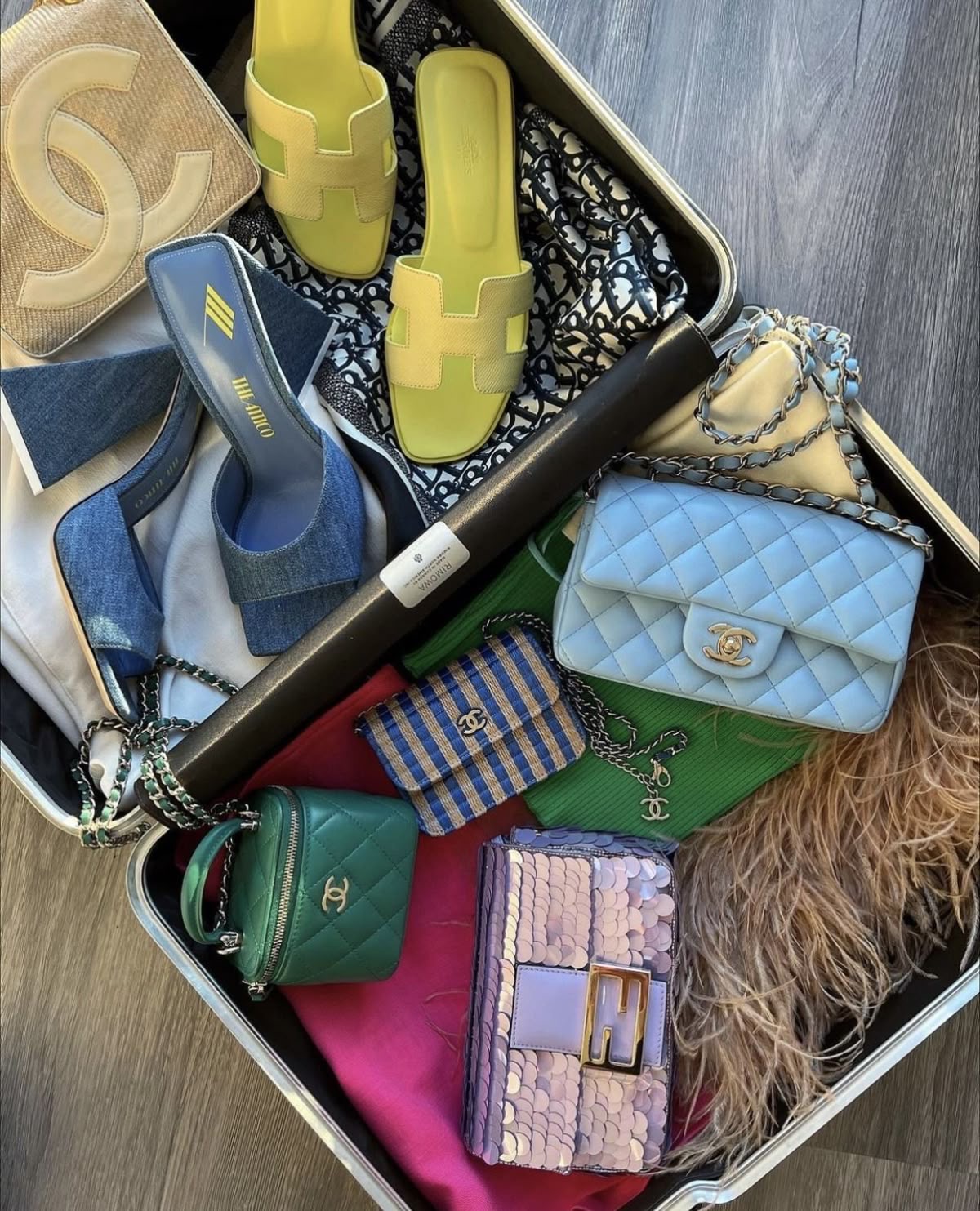 Open suitcase of designer handbags and shoes